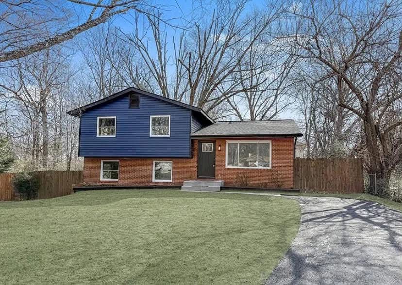 The same split-level after, with navy blue siding and a new front door