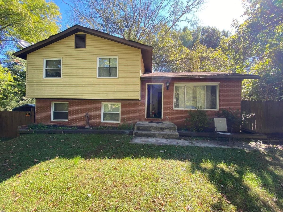 The split-level before, with faded yellow siding